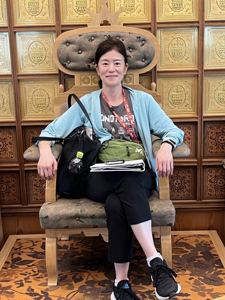 Personne assise sur une chaise ornée avec quelques affaires