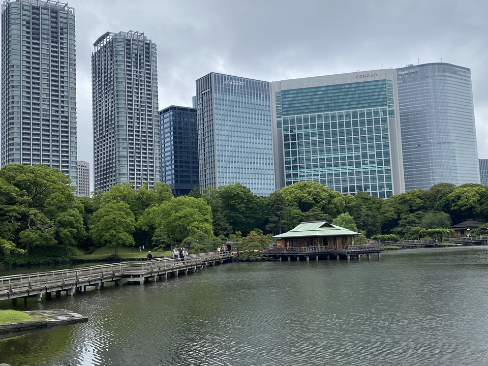 Étang avec maison de thé japonaise traditionnelle et horizon urbain moderne