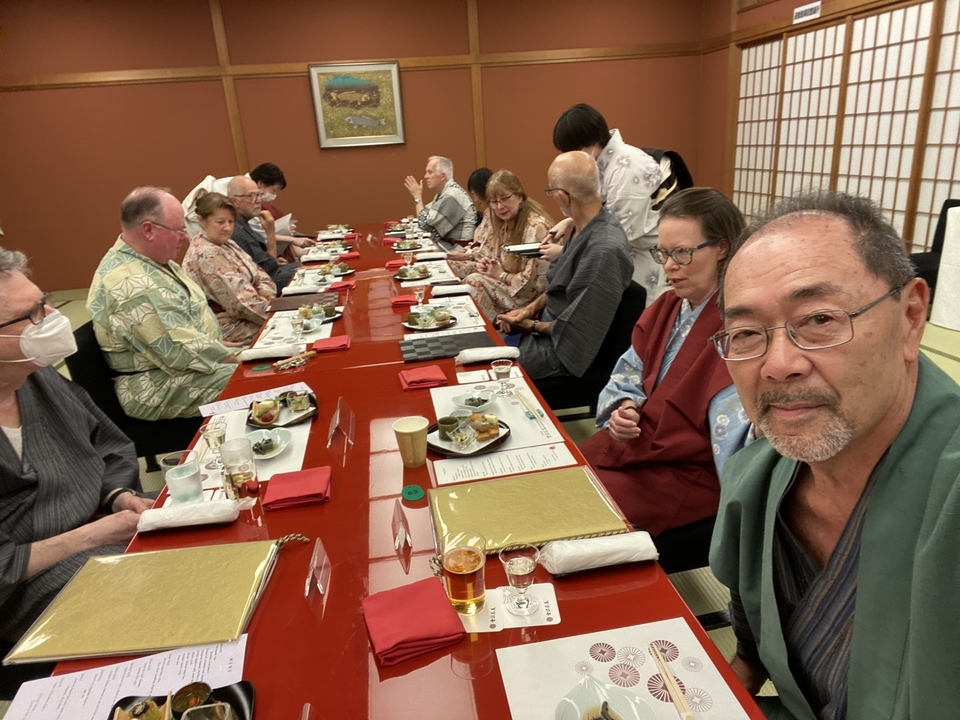 Groupe de personnes assises à une longue table de salle à manger en train de prendre un repas