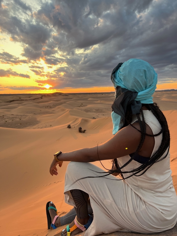 Personne profitant d'une vue sur les dunes de sable au coucher du soleil.