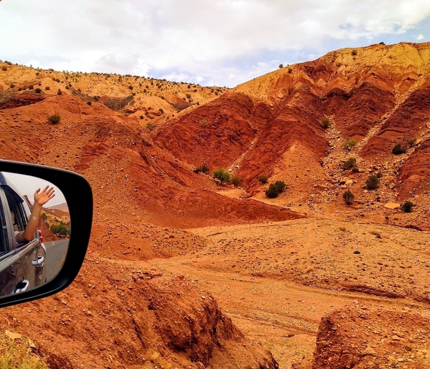 Terrain rocheux rouge vu depuis un rétroviseur de voiture.