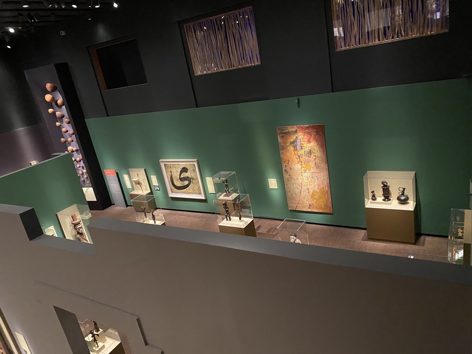 Museum interior with various paintings and artifacts on display.