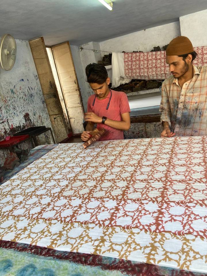 Artisan réalisant des impressions à la planche sur tissu.