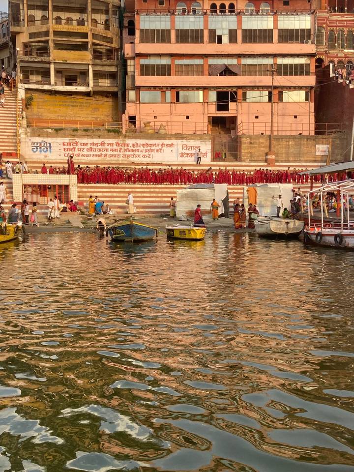 Des gens et des bateaux le long de la rivière au coucher du soleil.