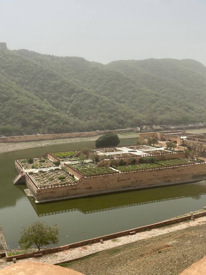 Jardin entouré d'un mur de fortification et de collines.