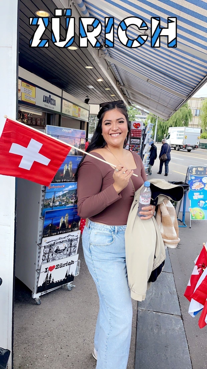 Frau hält eine Schweizer Flagge und lächelt.