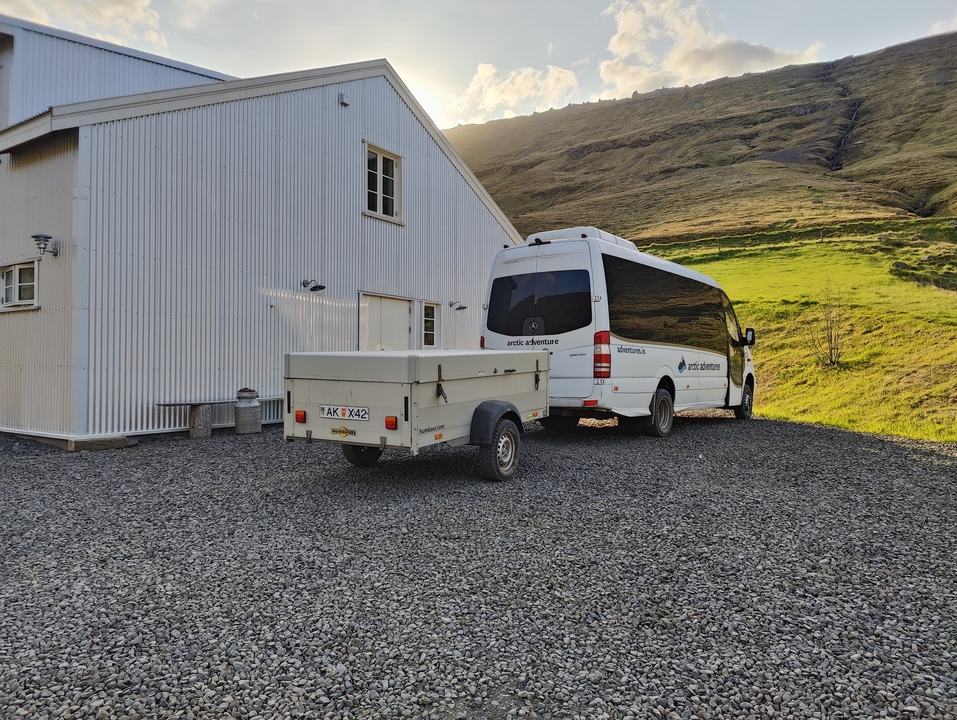A van parked next to a rural building in a green landscape
