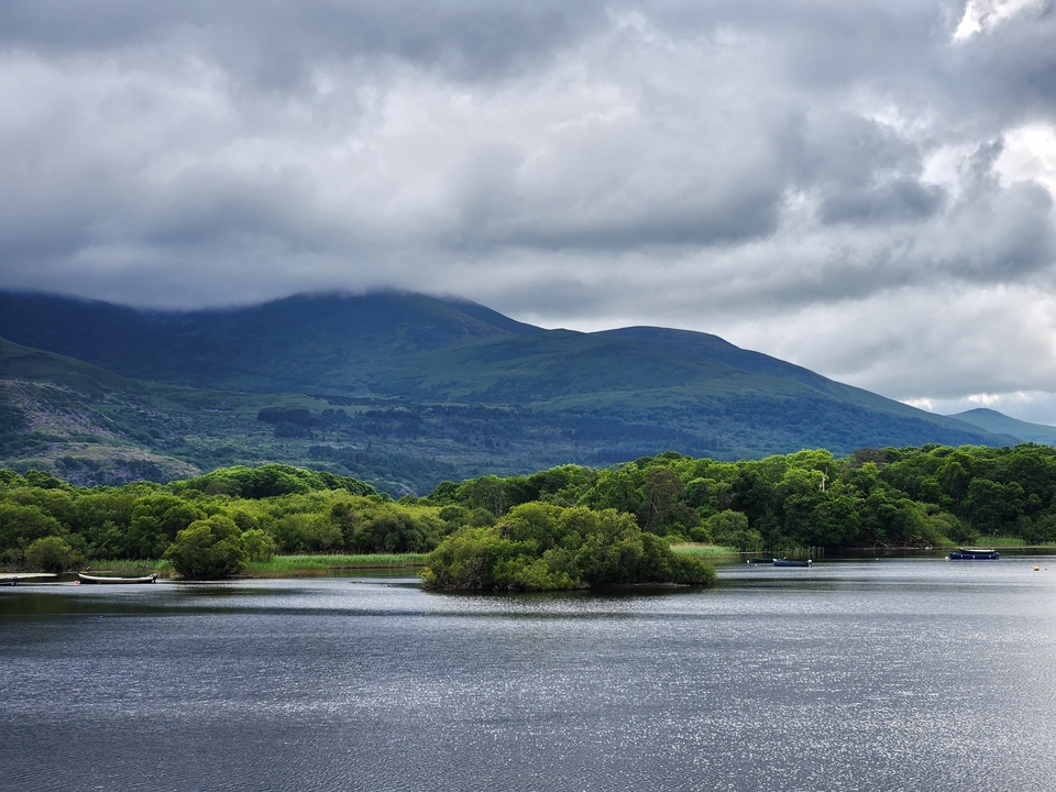 Un lac serein avec de luxuriantes collines vertes en arrière-plan en Irlande.