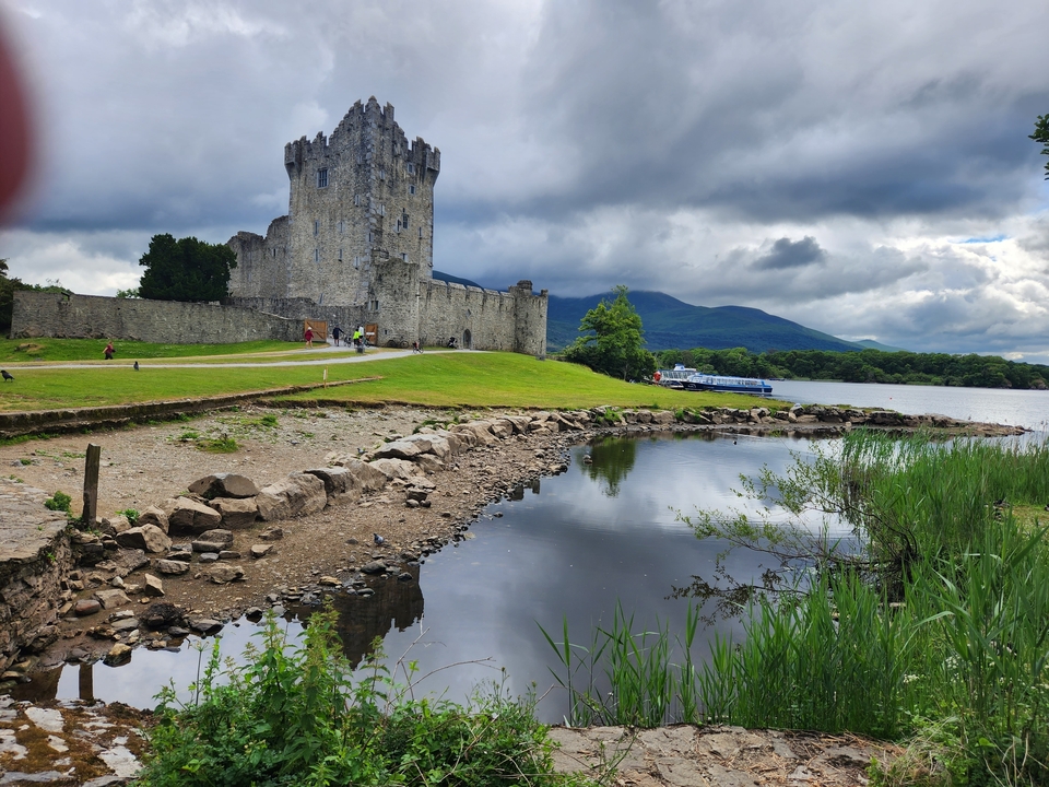 Château au bord d'un lac avec des montagnes en arrière-plan en Irlande.