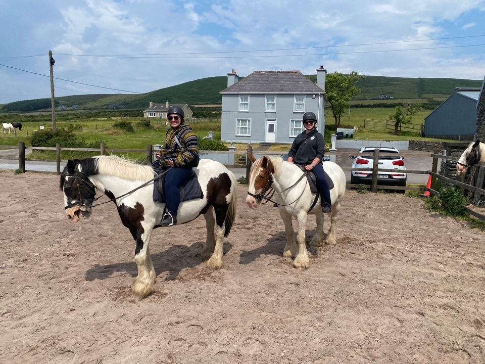 Deux personnes à cheval dans un cadre rural en Irlande.