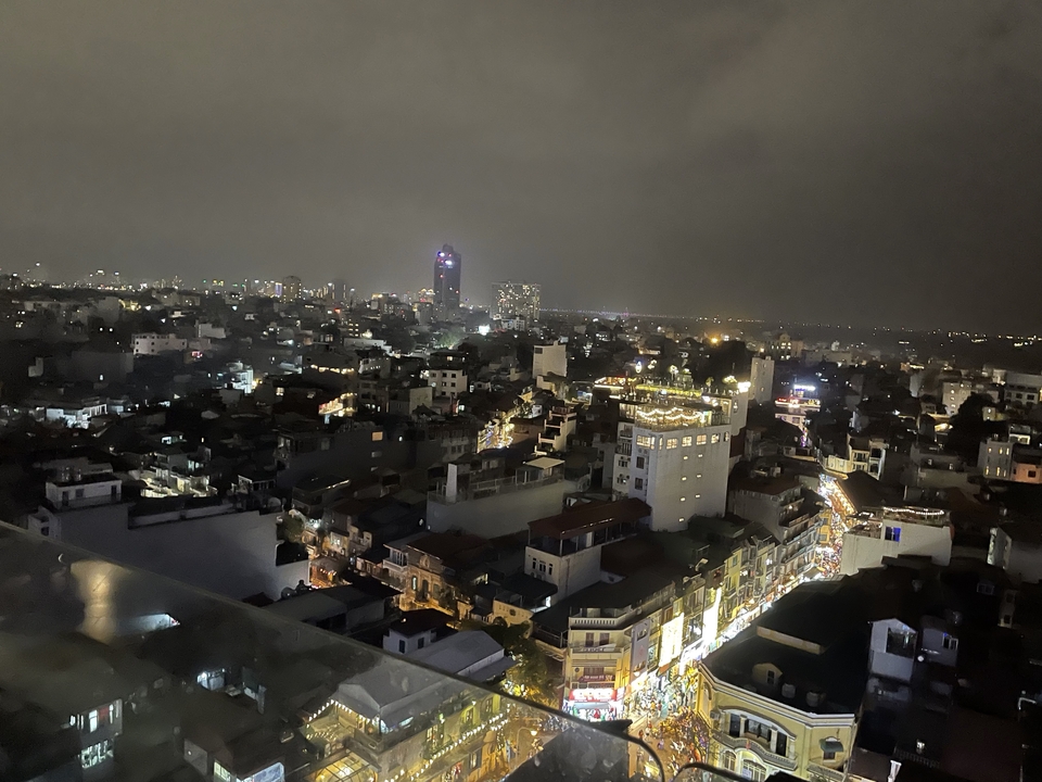 Skyline urbain la nuit avec des bâtiments illuminés et un ciel brumeux.