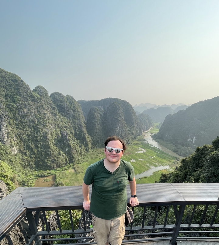 Personne avec des lunettes de soleil devant des montagnes karstiques calcaires au Vietnam.