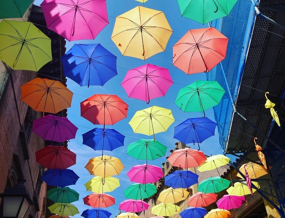 Des parapluies colorés suspendus au-dessus d'une rue.