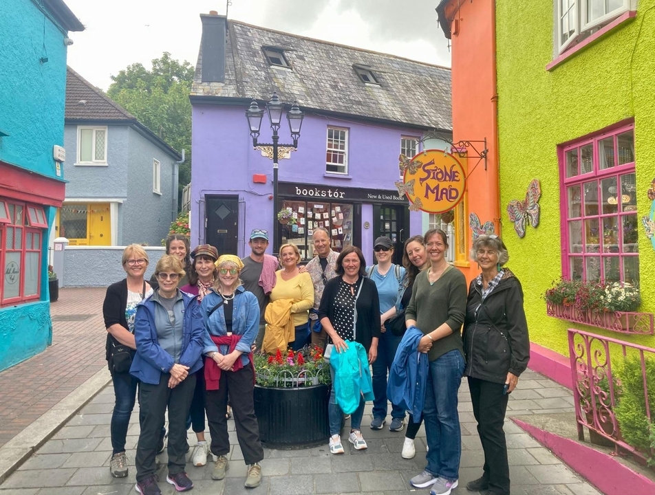 Group of people posing in front of colorful houses.