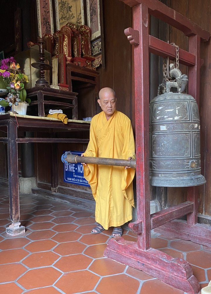 Moine tenant un marteau en bois dans un temple.