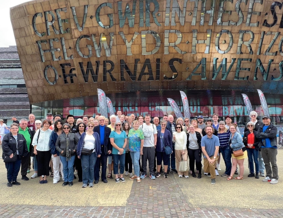 Large group of tourists in front of a cultural center.