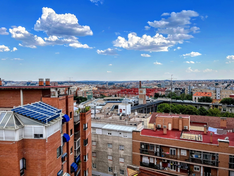 Cityscape with varying building heights and a cloudy sky.