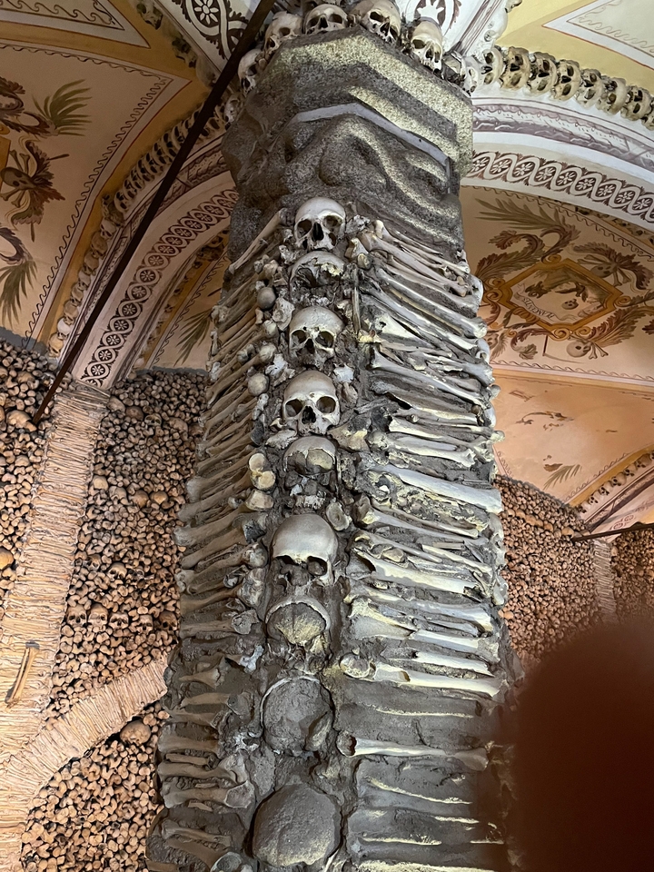 Column of stacked human bones and skulls in an ossuary.
