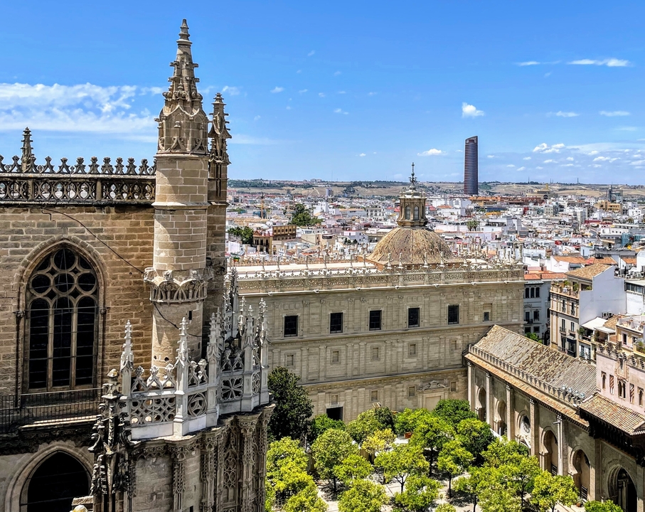 Panorama of a historic city with a cathedral and modern buildings.
