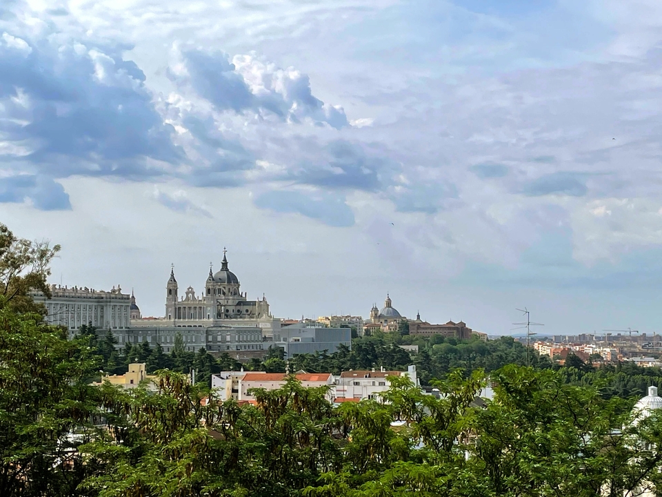 Madrid skyline with a historic palace and churches.