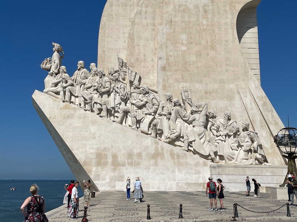 Monument featuring statues of explorers with a blue sky background.