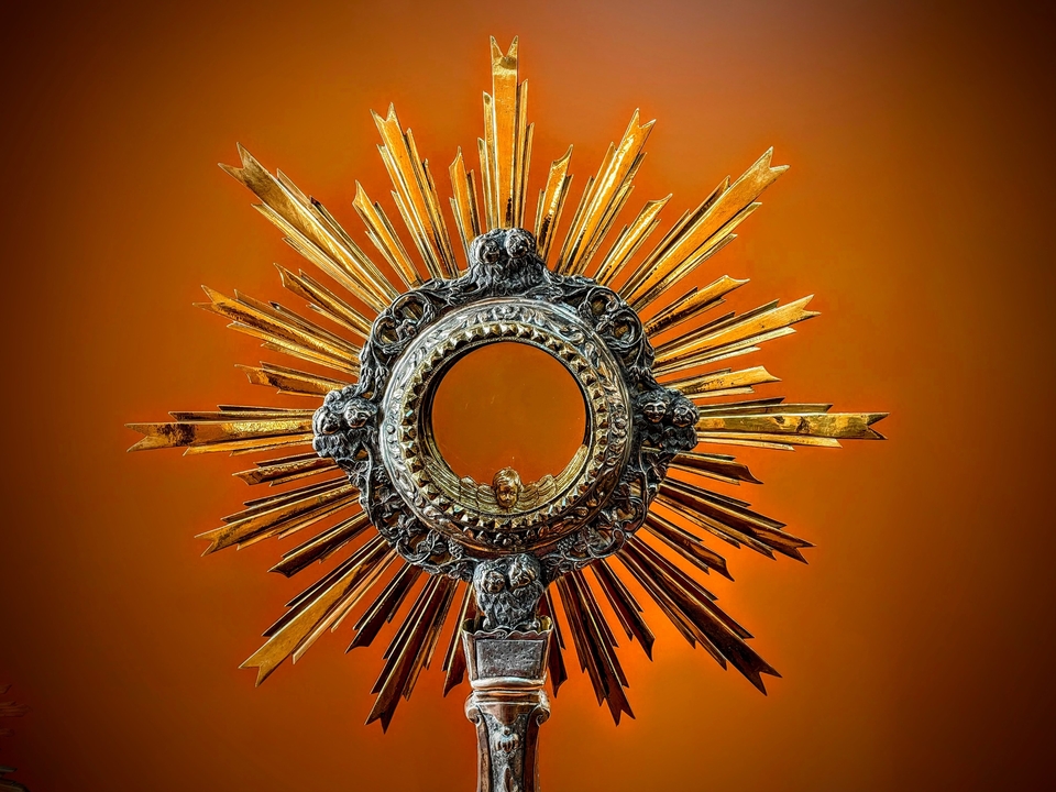 Religious relic in a ornate frame against a background.