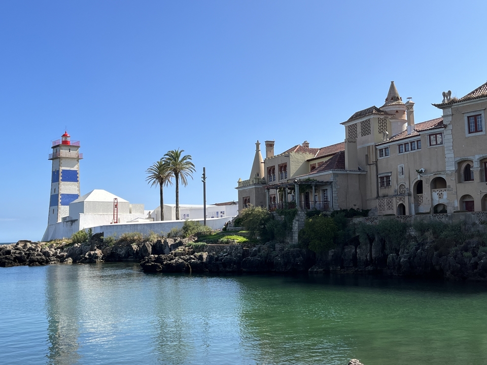 Vue sur le front de mer avec un phare et des bâtiments historiques.