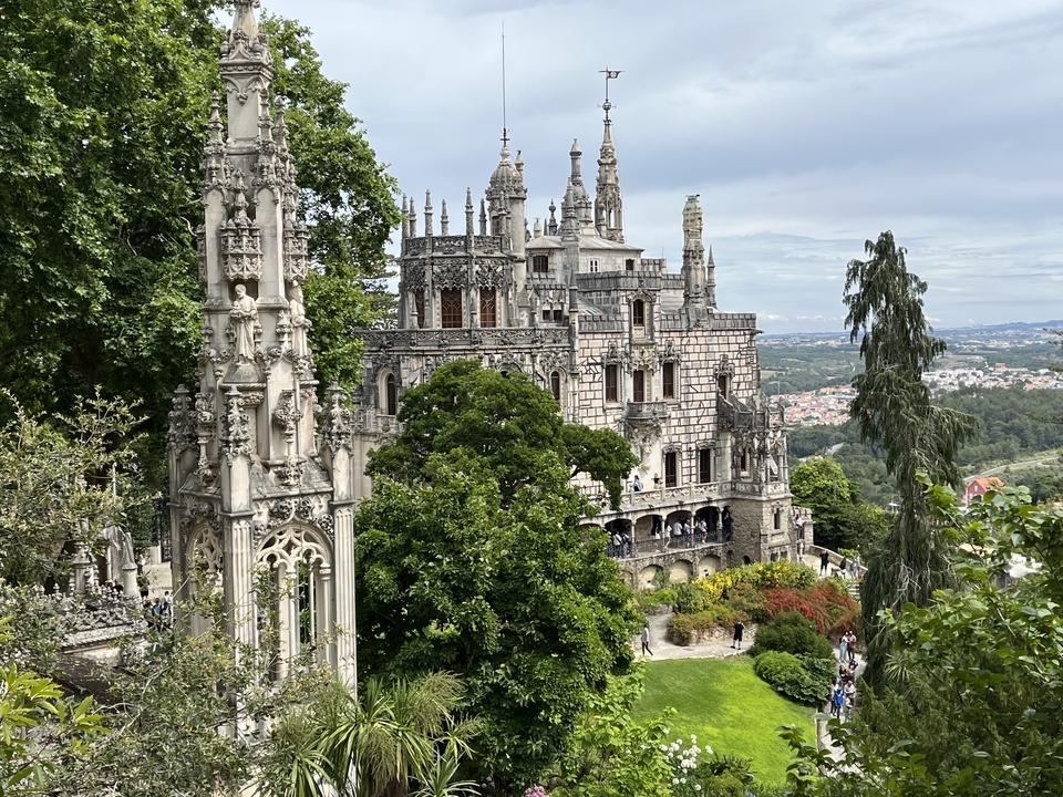 Château historique orné entouré d'arbres et de jardins.
