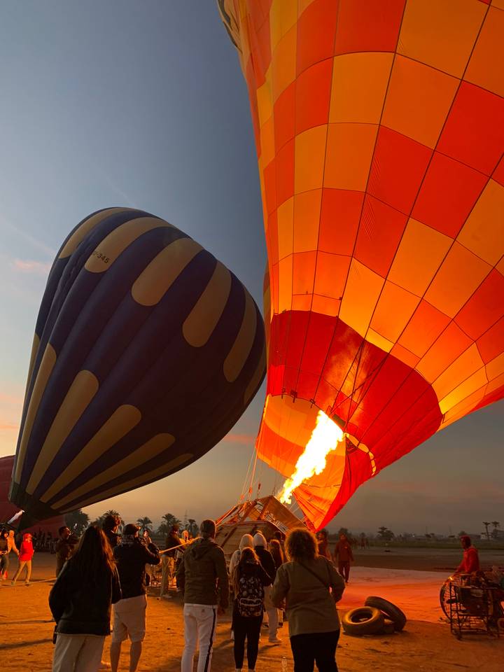 Hot air balloons being inflated before sunrise.