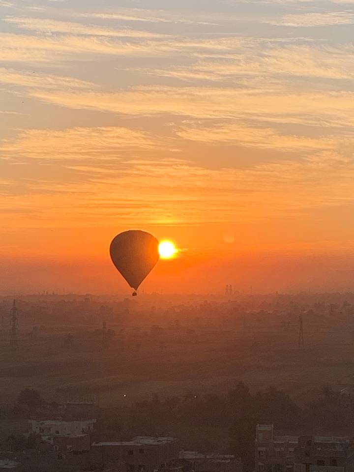 A hot air balloon in the sky during sunrise.