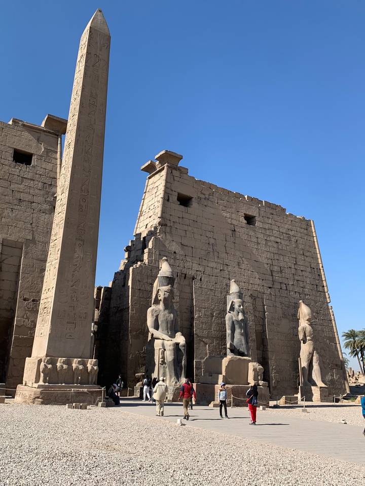 An ancient temple with obelisk and statues.