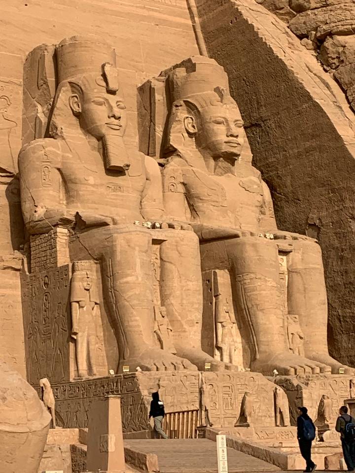 Carved statues of pharaohs on a temple wall.