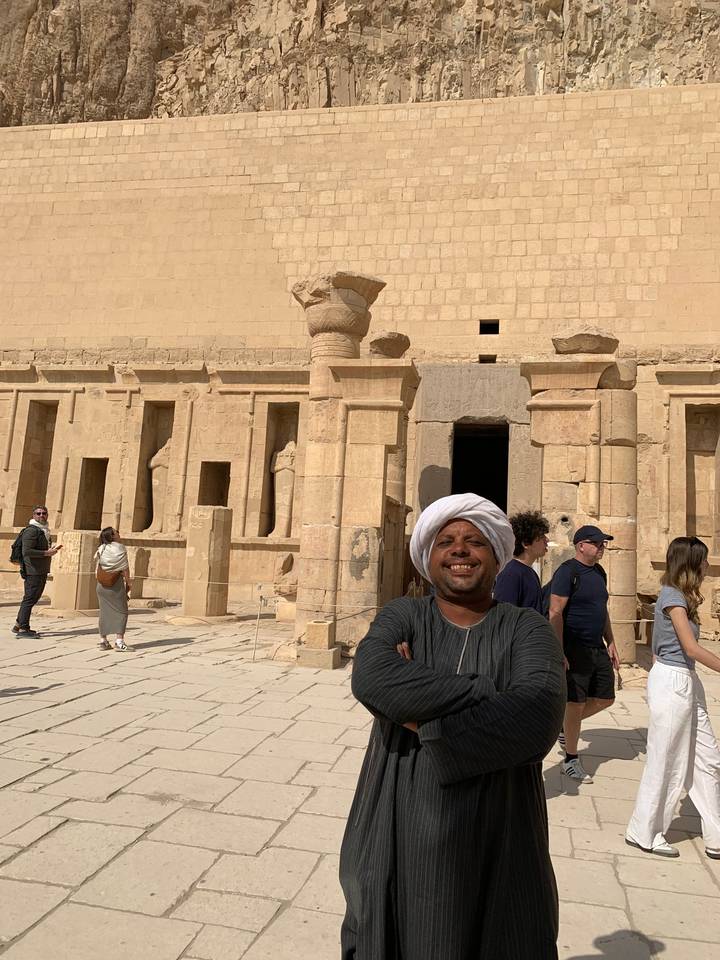 A person posing in front of an ancient temple.