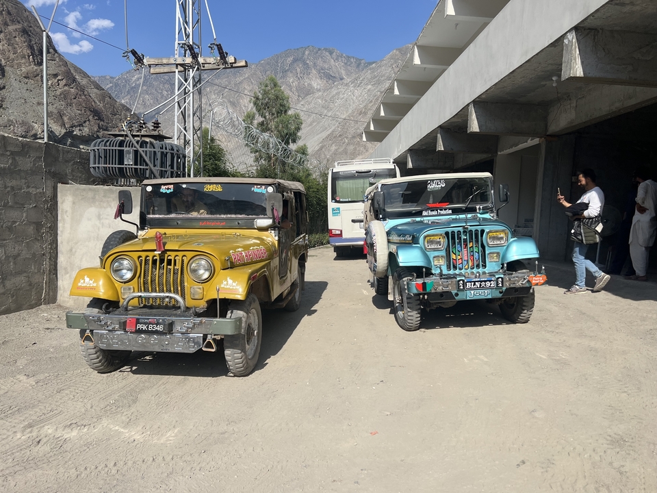 Des jeeps colorées garées dans une région montagneuse.