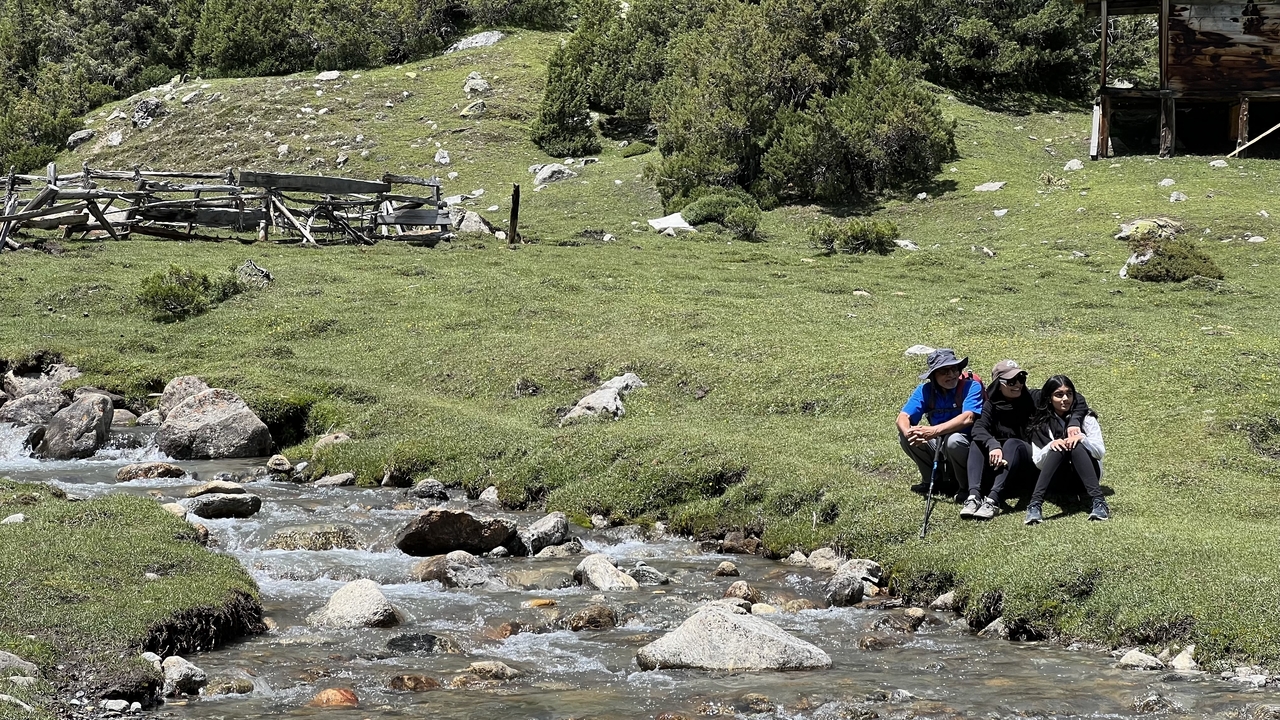 Un groupe de personnes assises près d'un ruisseau dans une zone luxuriante.