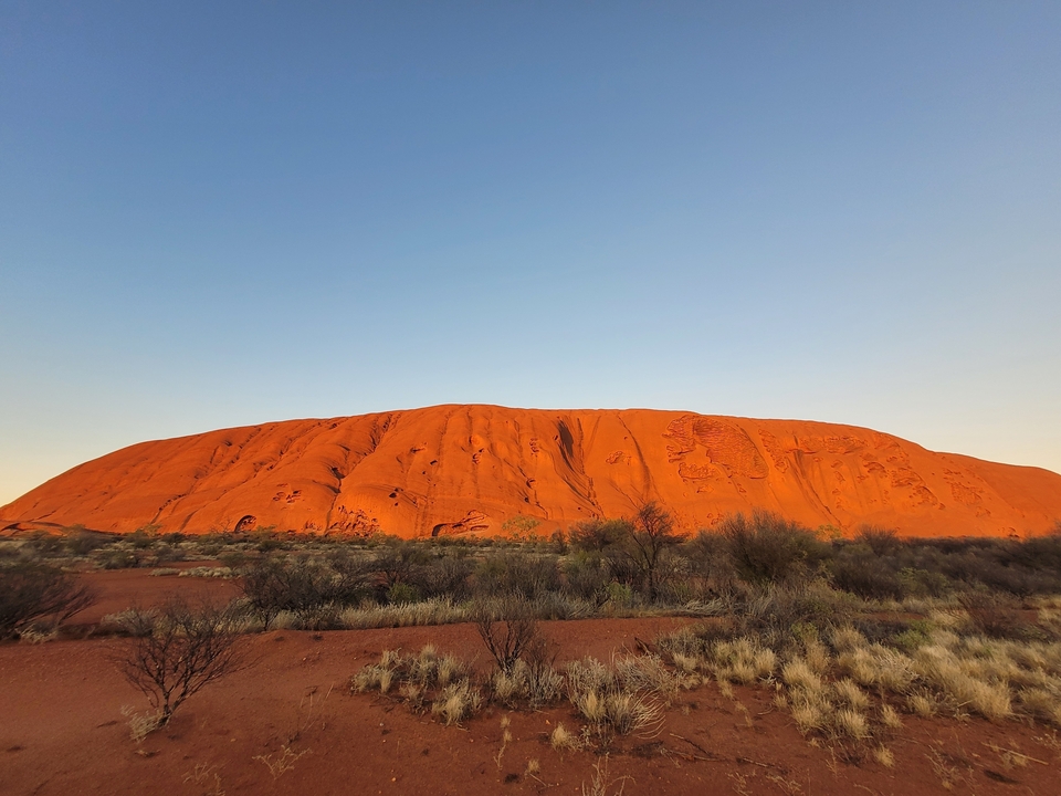 Uluru au crépuscule avec un ciel dégagé.
