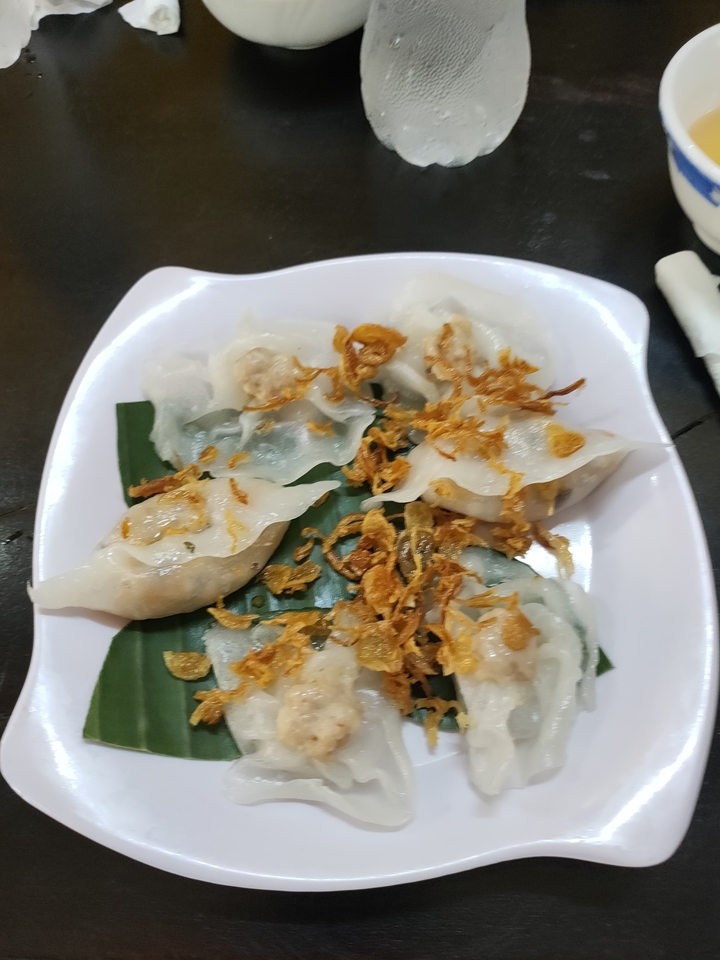 Assiette de boulettes avec des oignons frits sur une feuille de bananier.