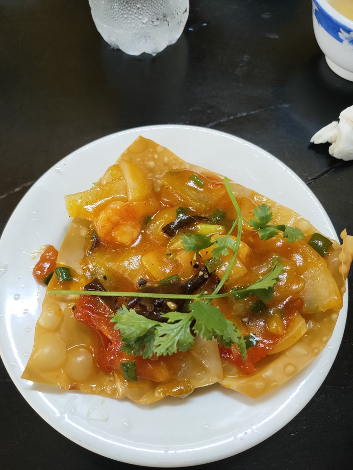 Gros plan d'un plat vietnamien avec des crevettes et des herbes.