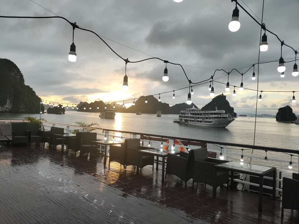 Salle à manger d'un navire de croisière avec vue sur le coucher de soleil de la baie d'Halong.