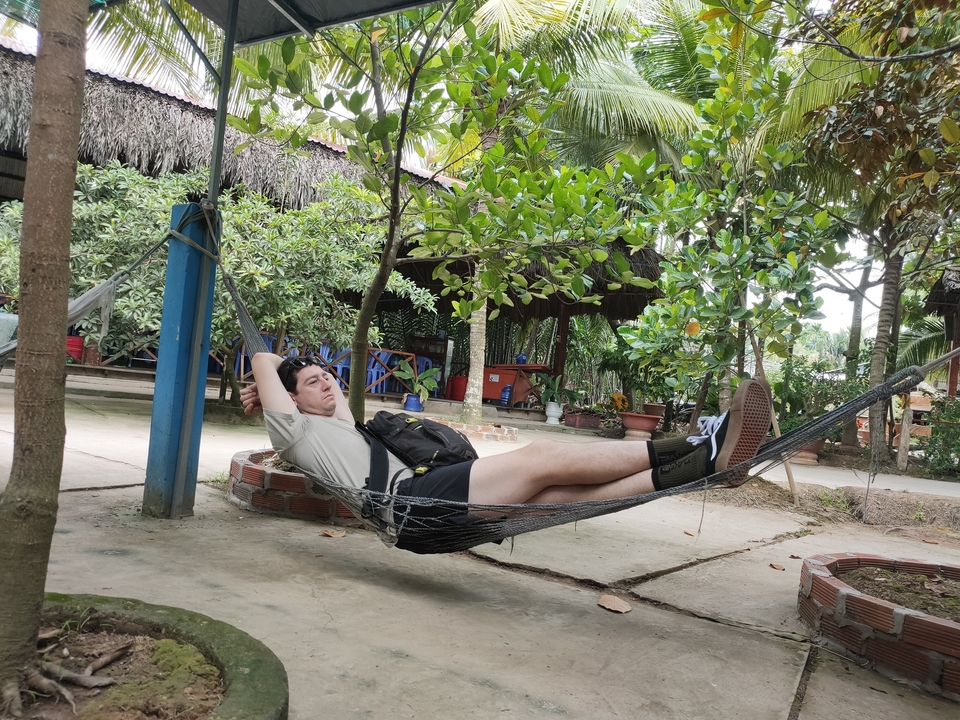 Personne se relaxant dans un hamac dans un cadre de jardin.