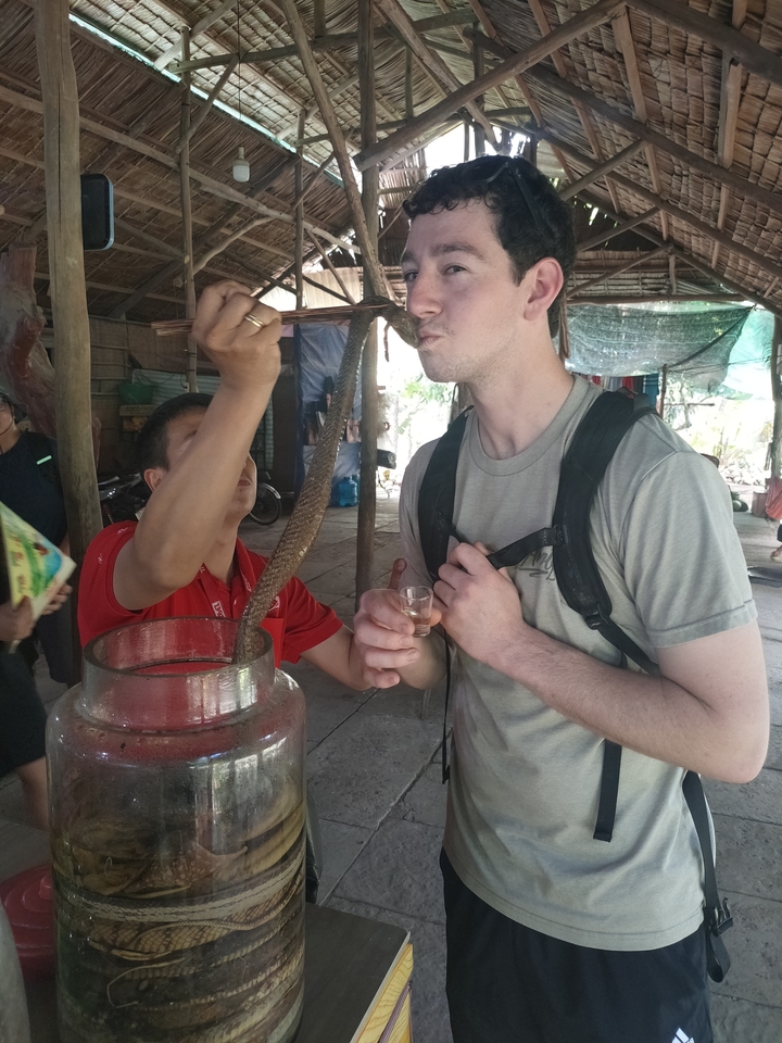 Homme buvant une boisson dans un cadre traditionnel.