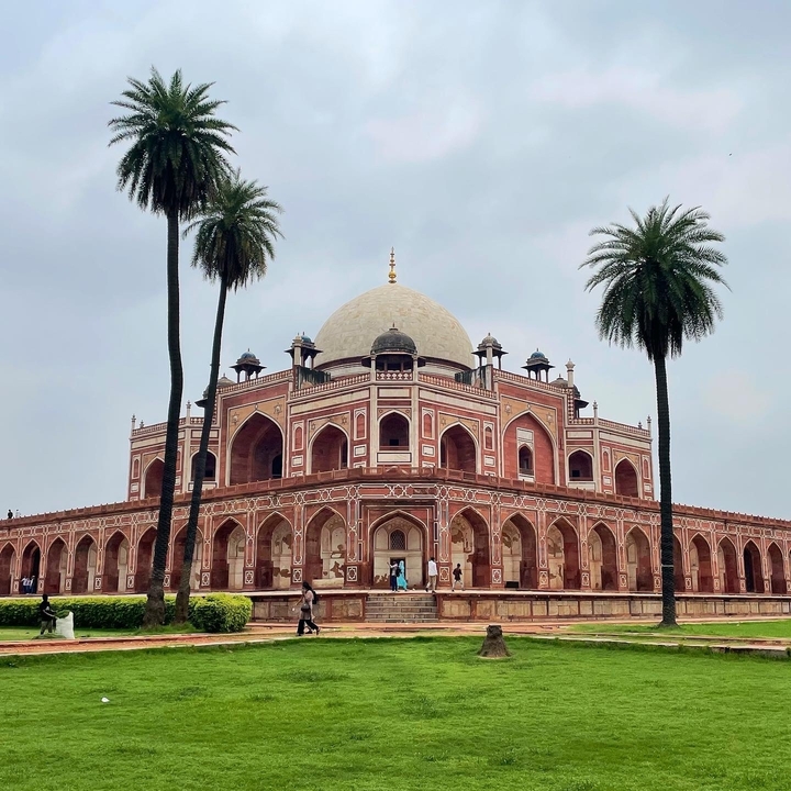 Le Tombeau de Humayun avec une végétation luxuriante et des gens.