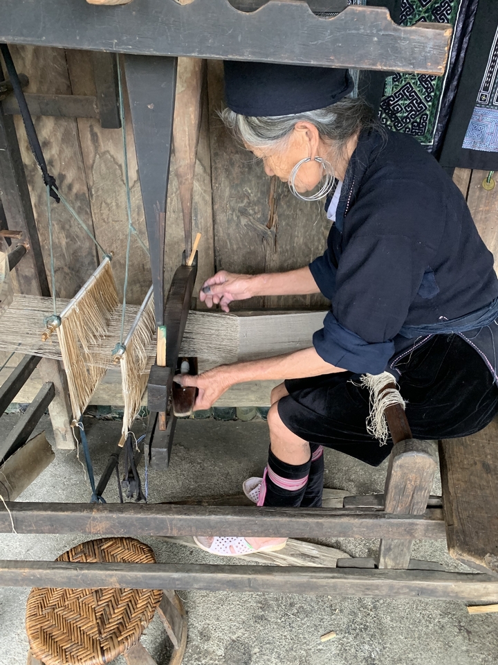 Une personne qui tisse en utilisant un métier à tisser traditionnel.