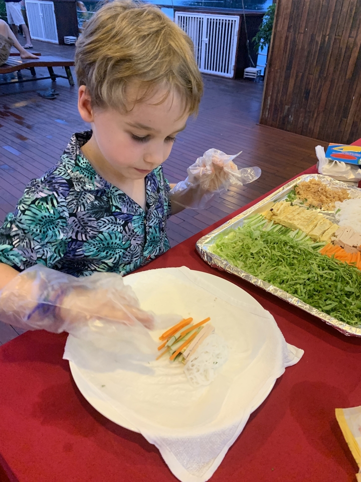 Un enfant qui prépare de la nourriture avec des légumes dans une assiette.