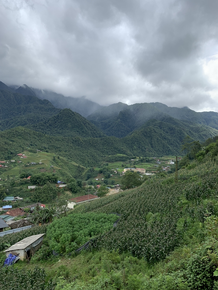 Paysage montagneux avec vallées et maisons dispersées.