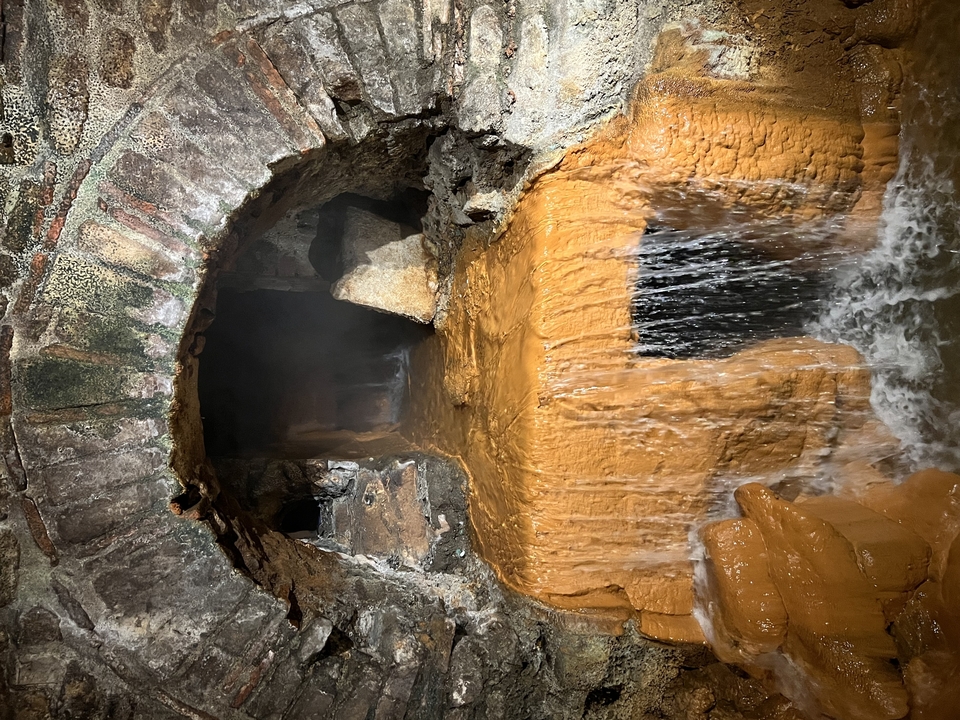 Ancienne structure de pierre avec de l'eau qui coule dessus.