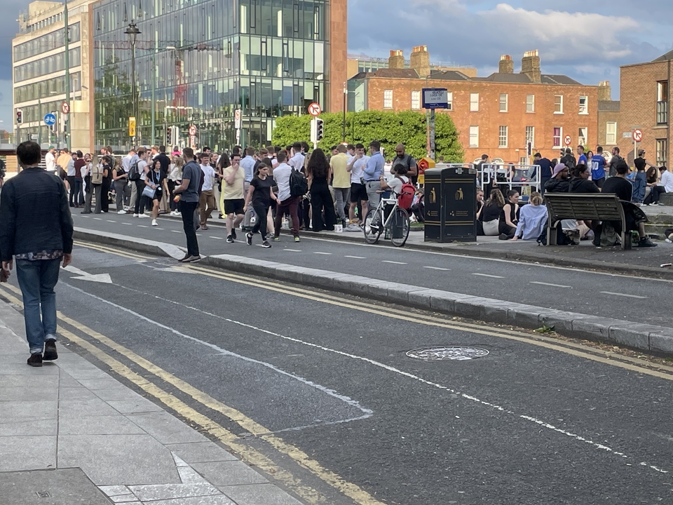 Grand groupe de personnes rassemblées dans une rue pour un événement.