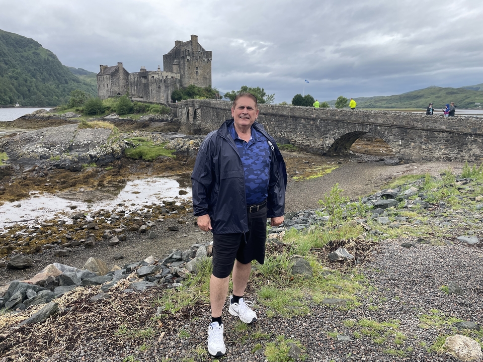 Homme devant le château historique d'Eilean Donan.