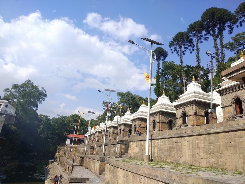 Temples entourés d'une végétation luxuriante sous un ciel partiellement nuageux.