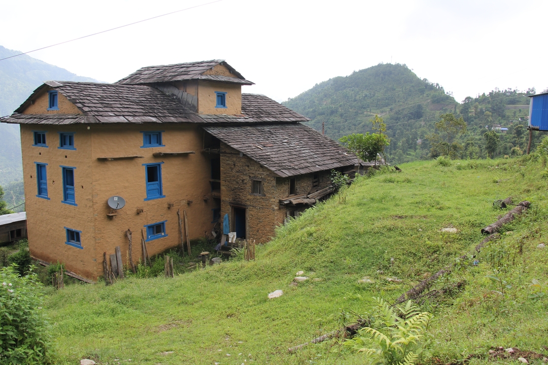 Maison traditionnelle dans un paysage vallonné.
